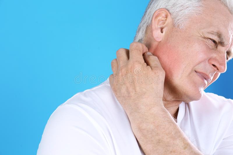 senior man scratching back of neck